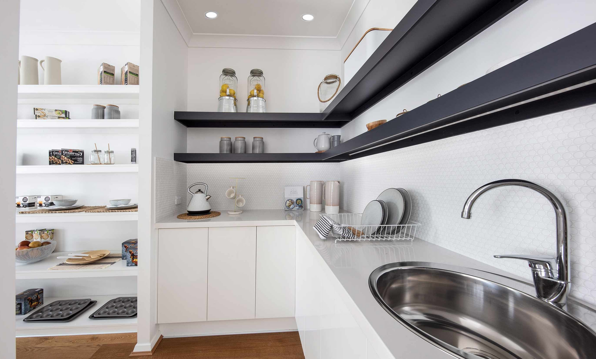 A kitchen with white cabinets and a stainless steel sink.