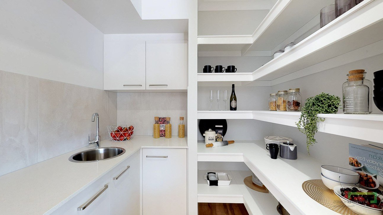 A kitchen with white cabinets and shelves and a sink.