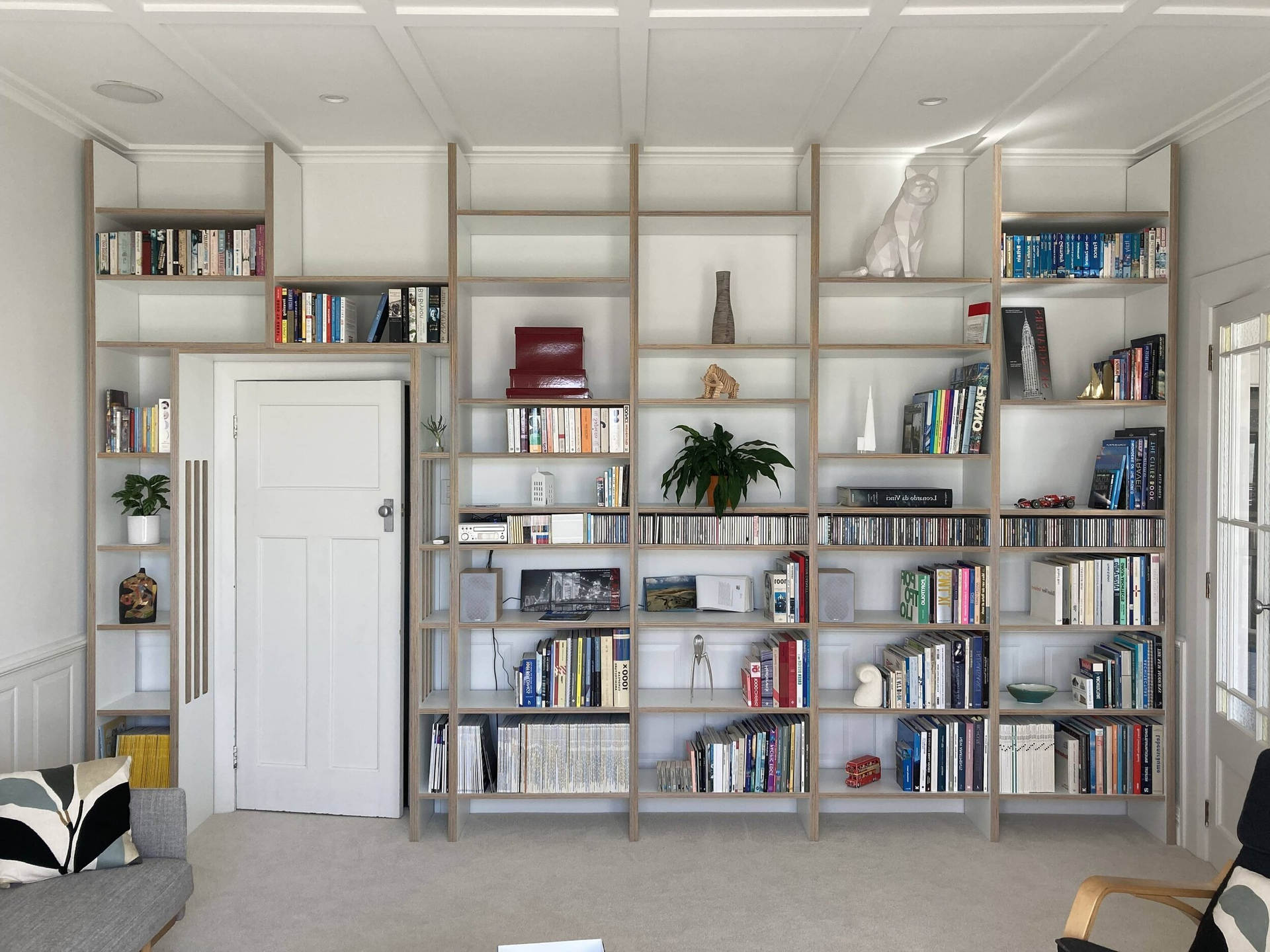 A living room with a lot of books on the shelves.