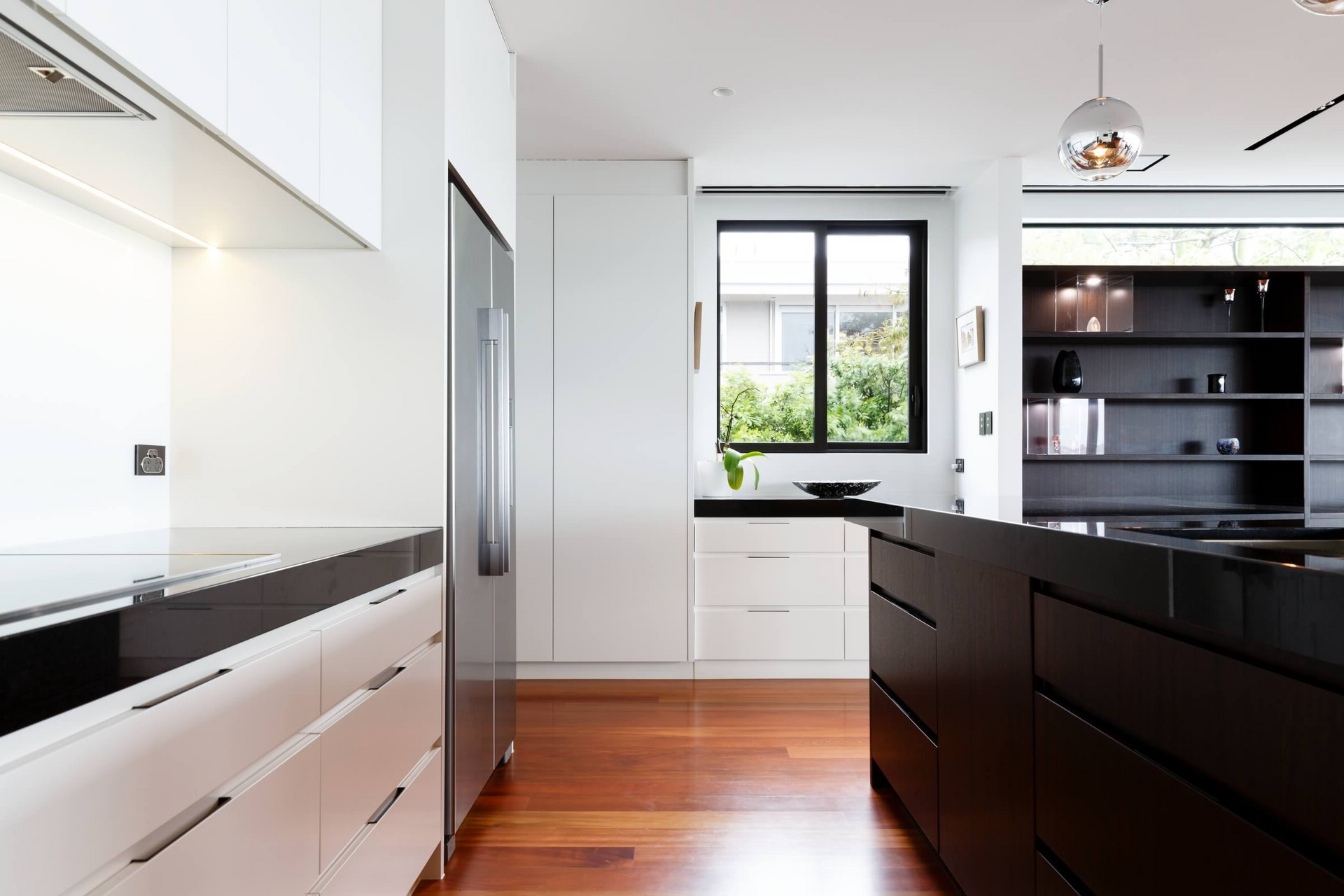A kitchen with white cabinets and black counter tops.