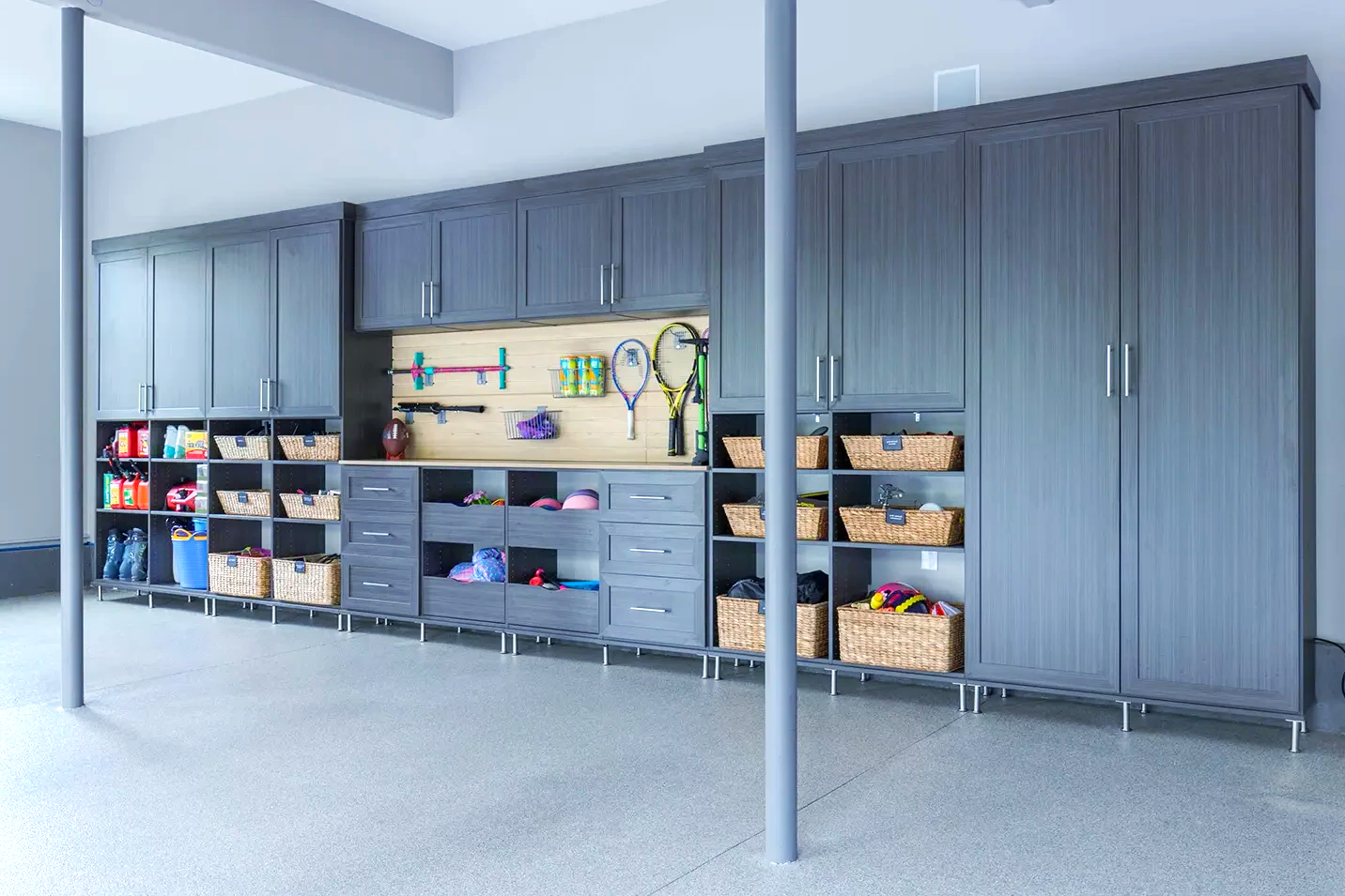A large garage with lots of cabinets and shelves and a workbench.