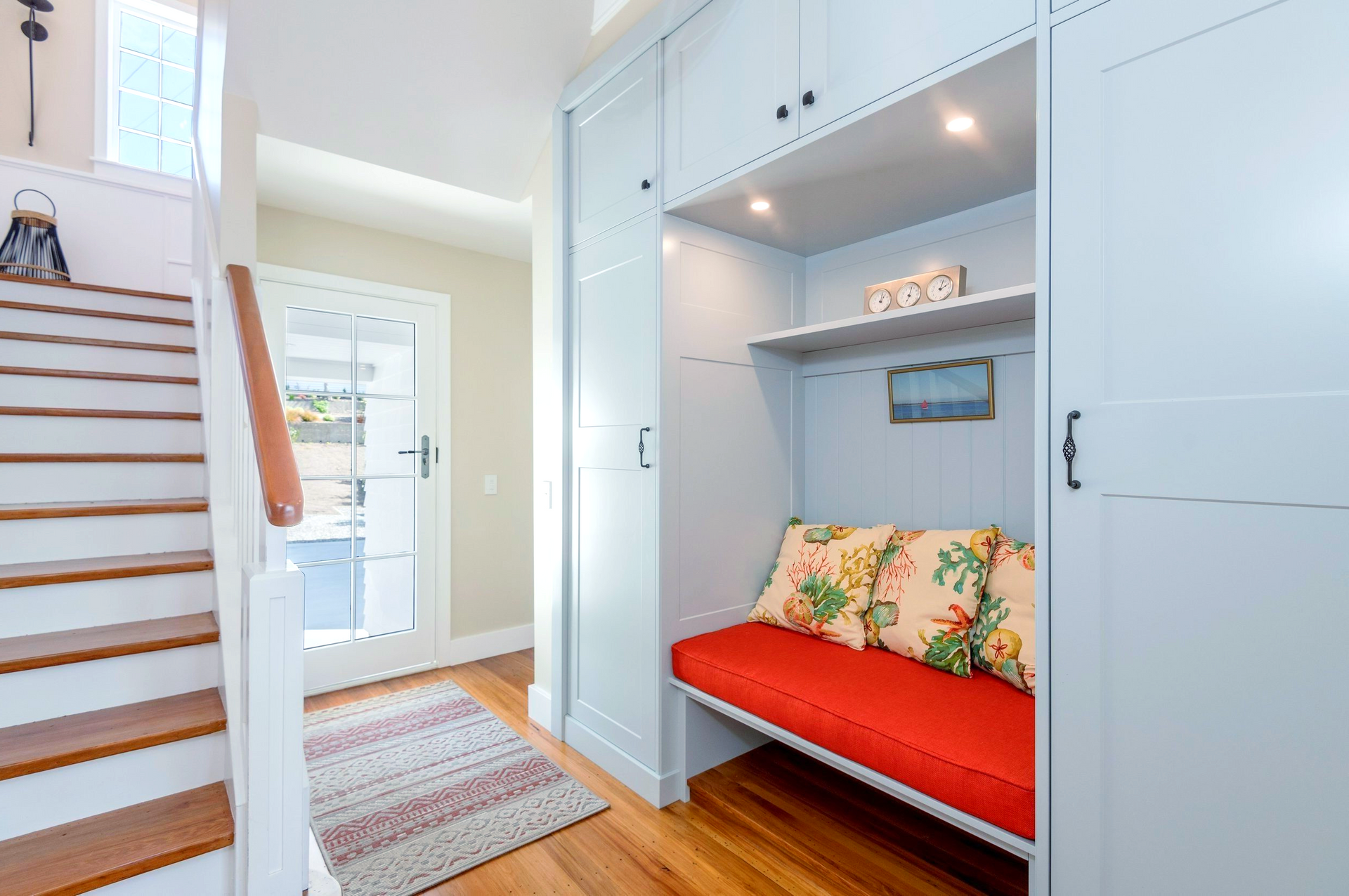 A hallway with stairs and a bench in the middle of it.