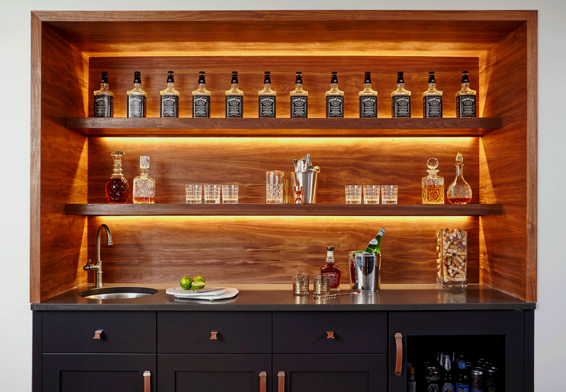 There are many bottles of alcohol on the shelves in this bar.