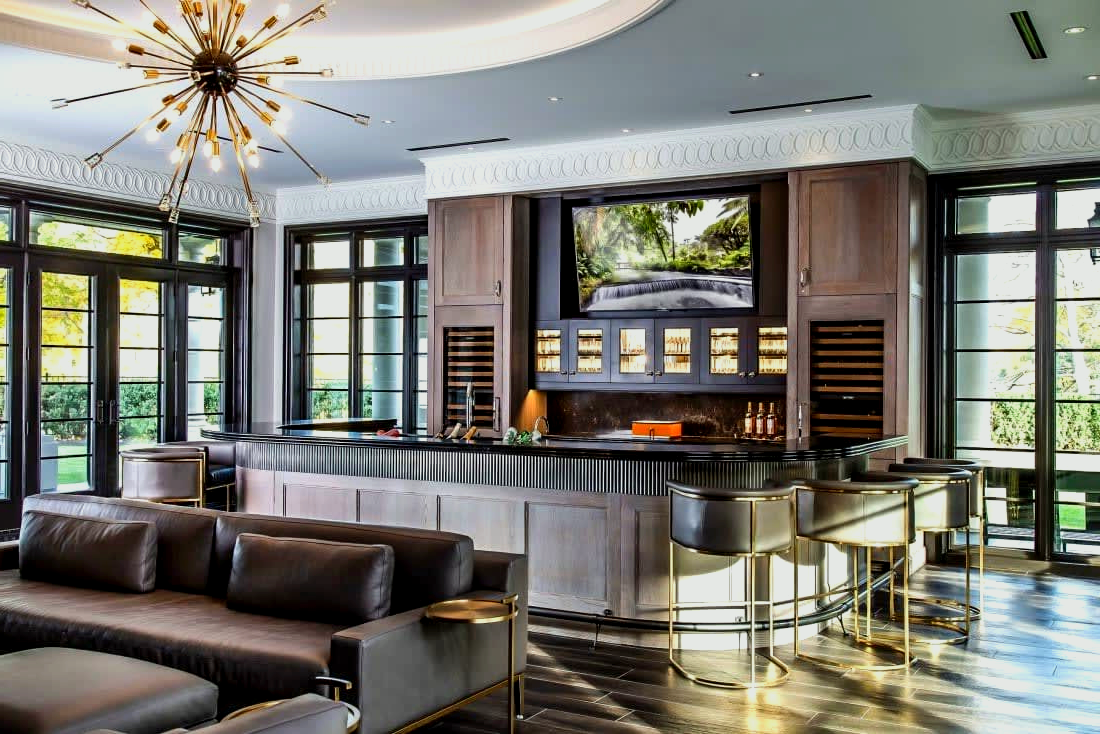 A living room with a couch, bar and television.