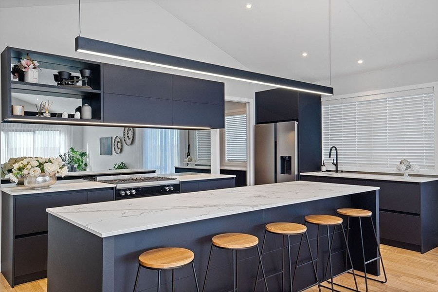 A kitchen with a large island and stools.
