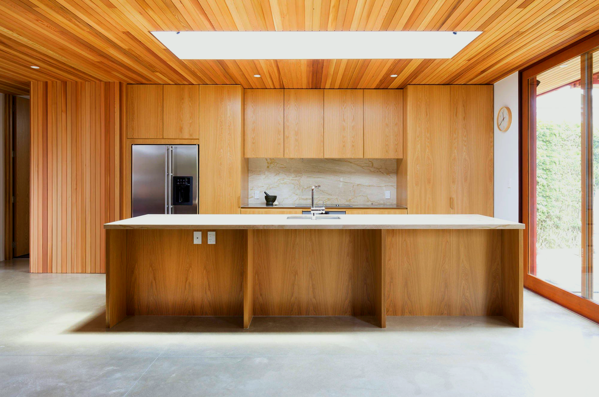 A kitchen with wooden cabinets and a stainless steel refrigerator.