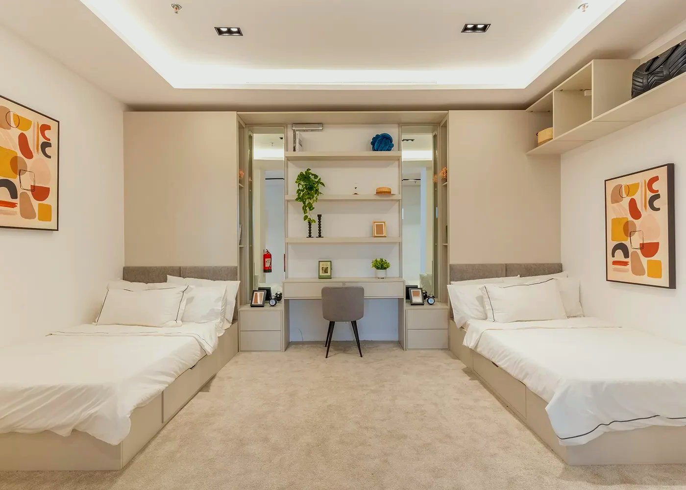 A bedroom with two beds and a desk.