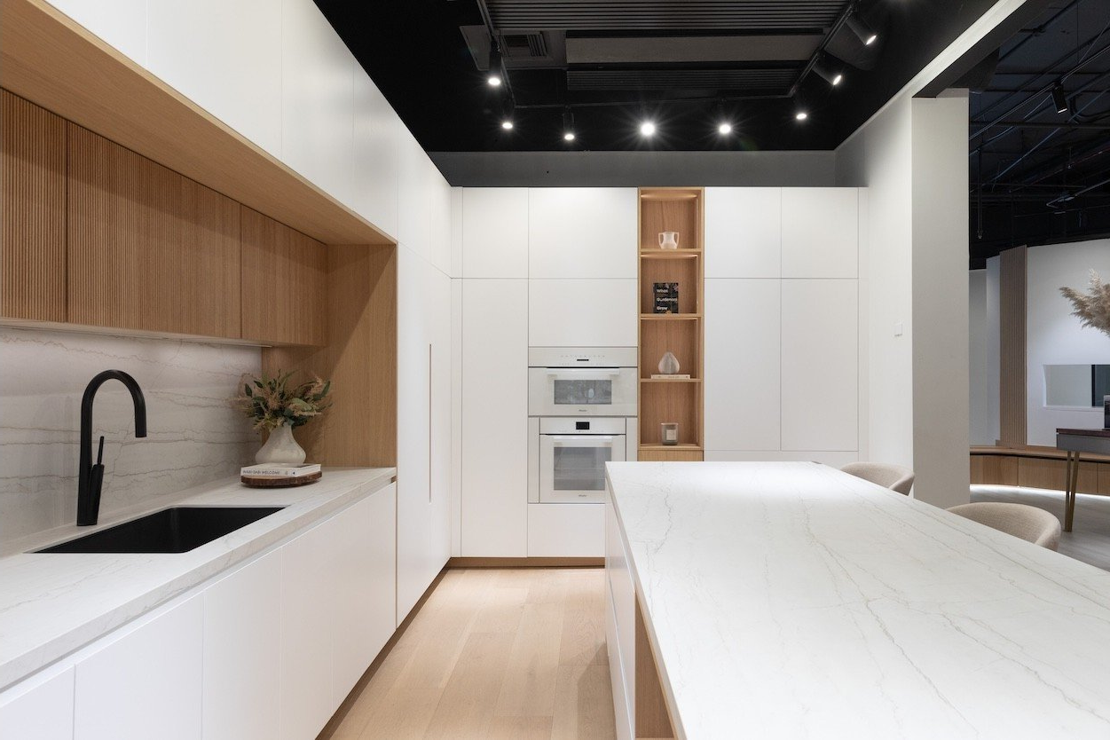 A kitchen with white cabinets, a sink, and a large island.