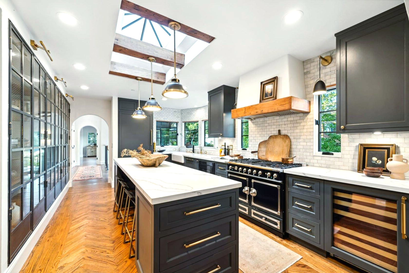 A kitchen with black cabinets and a large island in the middle.