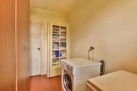 a laundry room with a washer, a dryer, and a cabinet full of folded clothes and towels