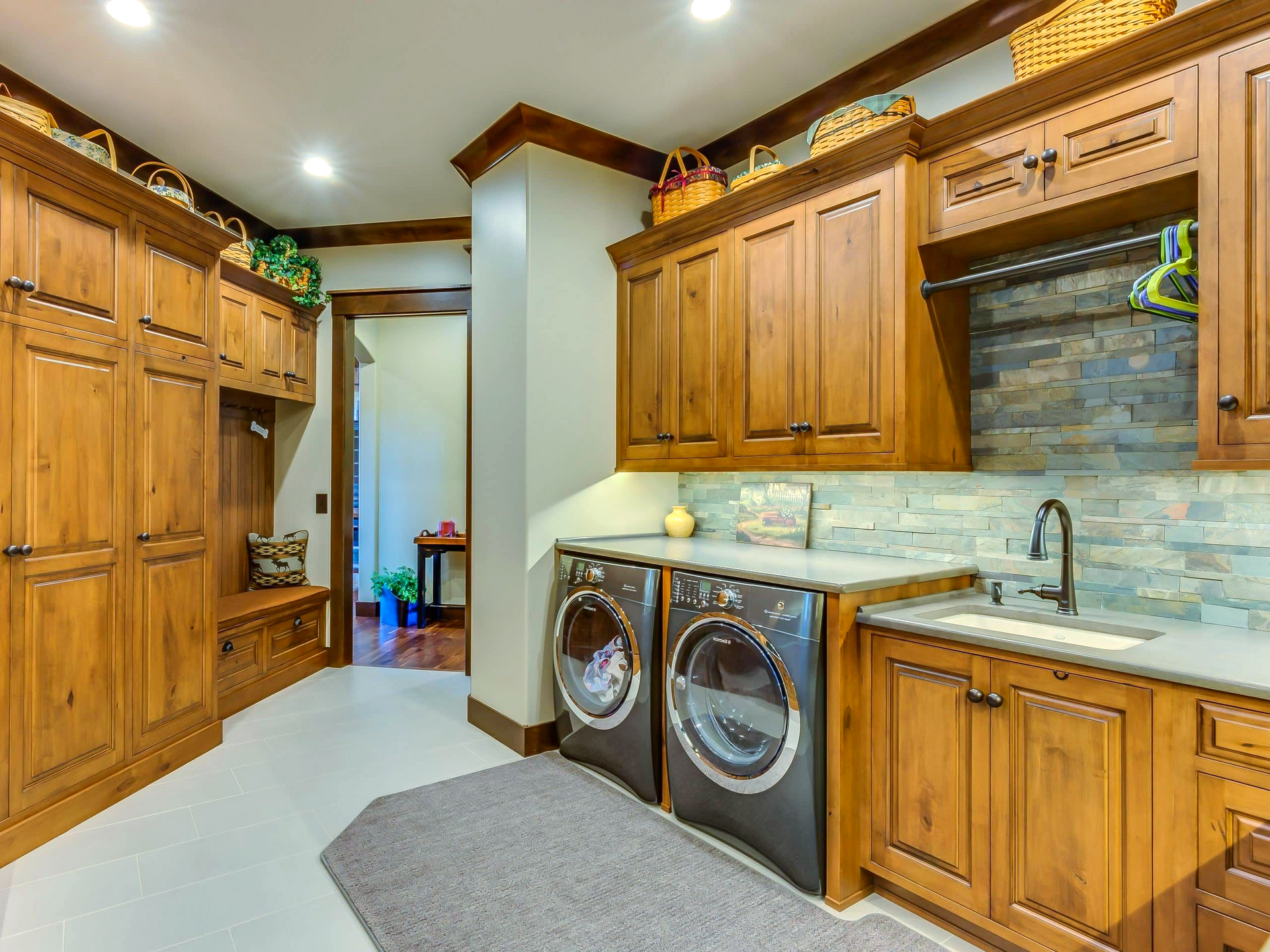 A laundry room with a washer and dryer and wooden cabinets.
