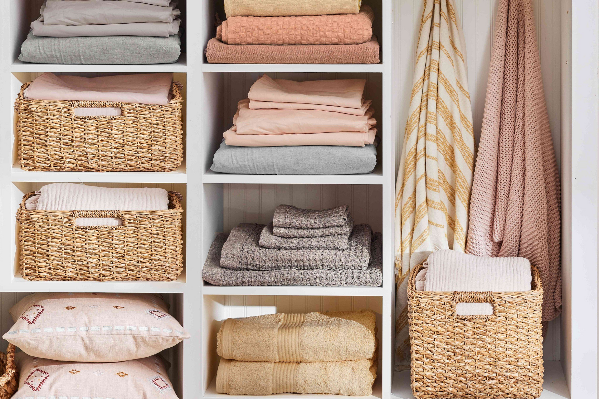 A closet filled with lots of towels and baskets.