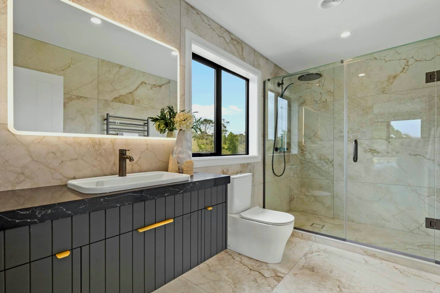 A bathroom with a toilet, sink, mirror and walk in shower.