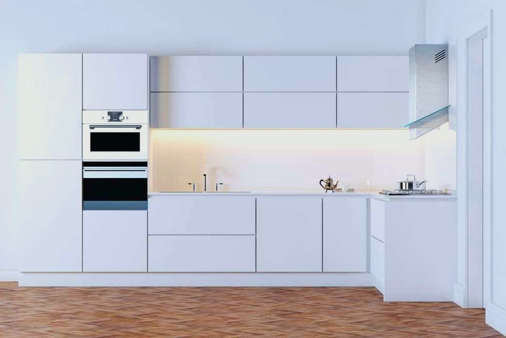 A kitchen with white minimalist cabinets