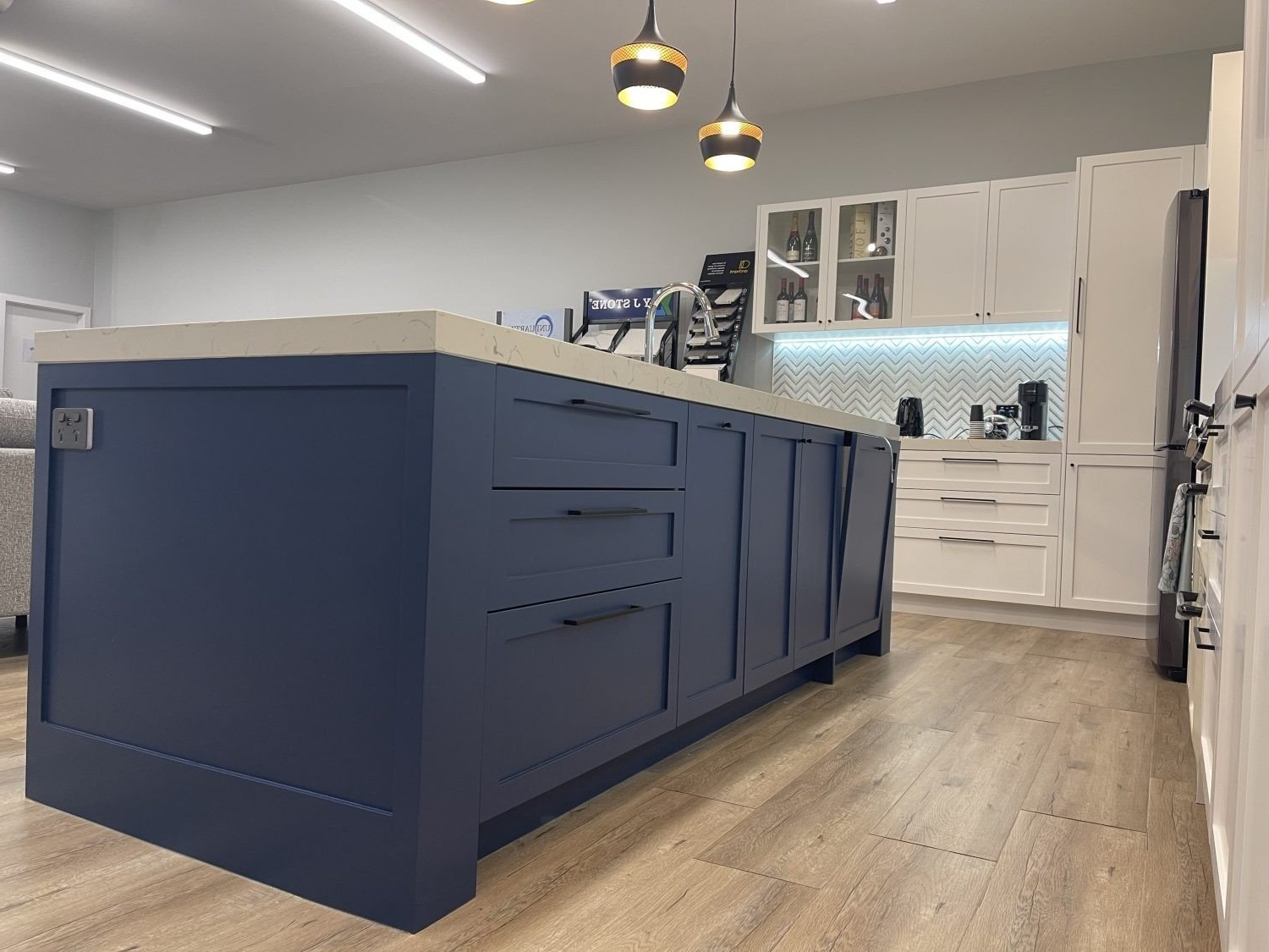 A kitchen with blue cabinets and a large island in the middle.