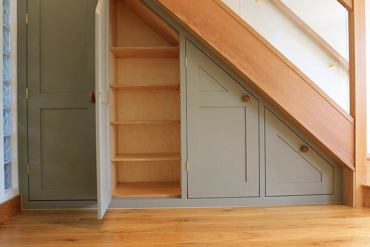 A staircase with a closet underneath it.