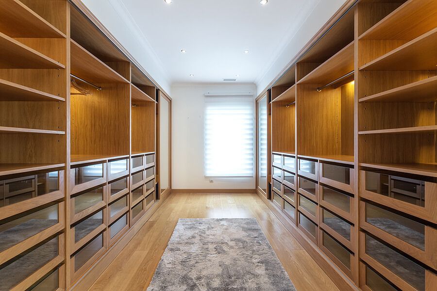 A large walk in closet with lots of shelves and drawers.