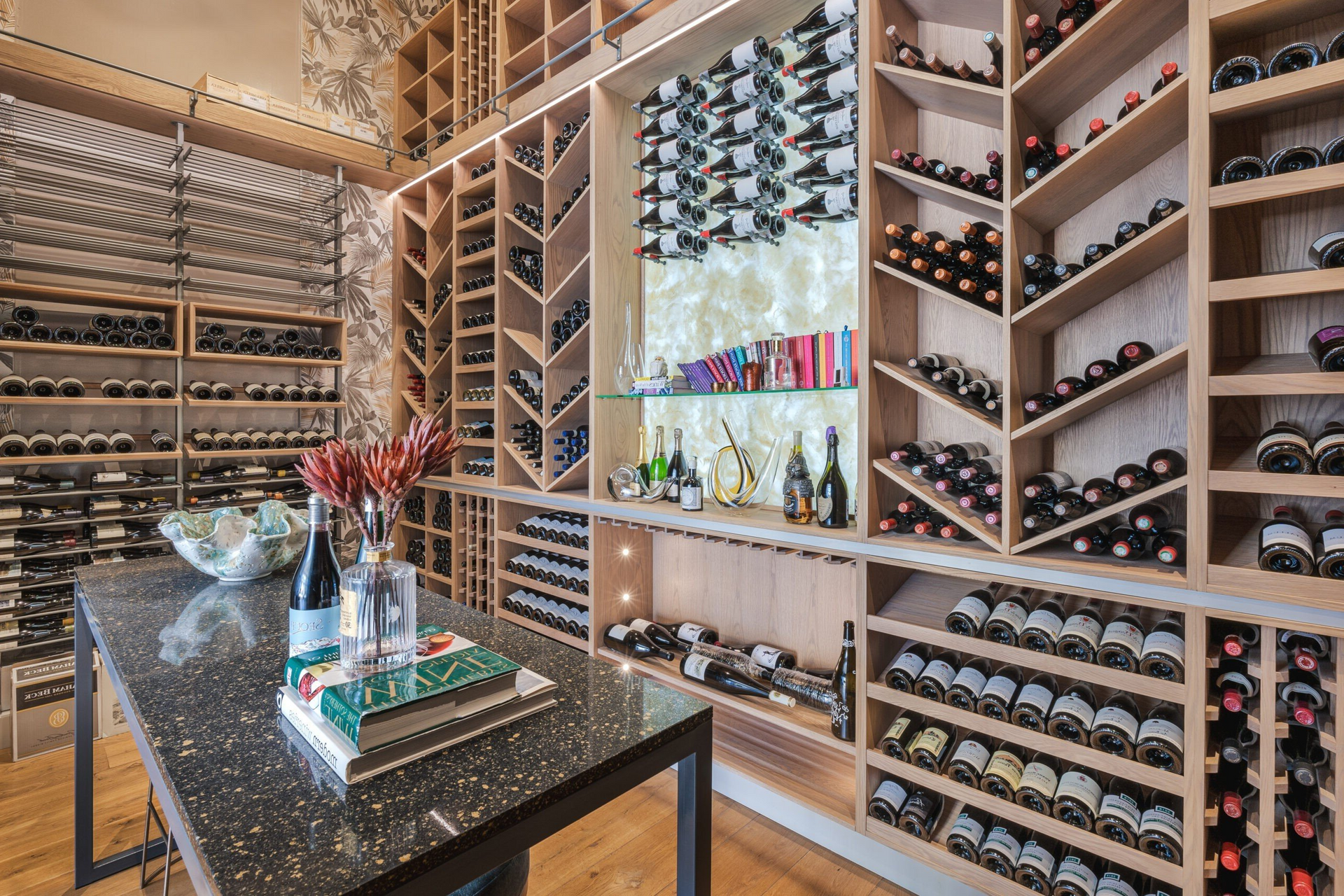 A wine cellar filled with lots of bottles of wine and a table.