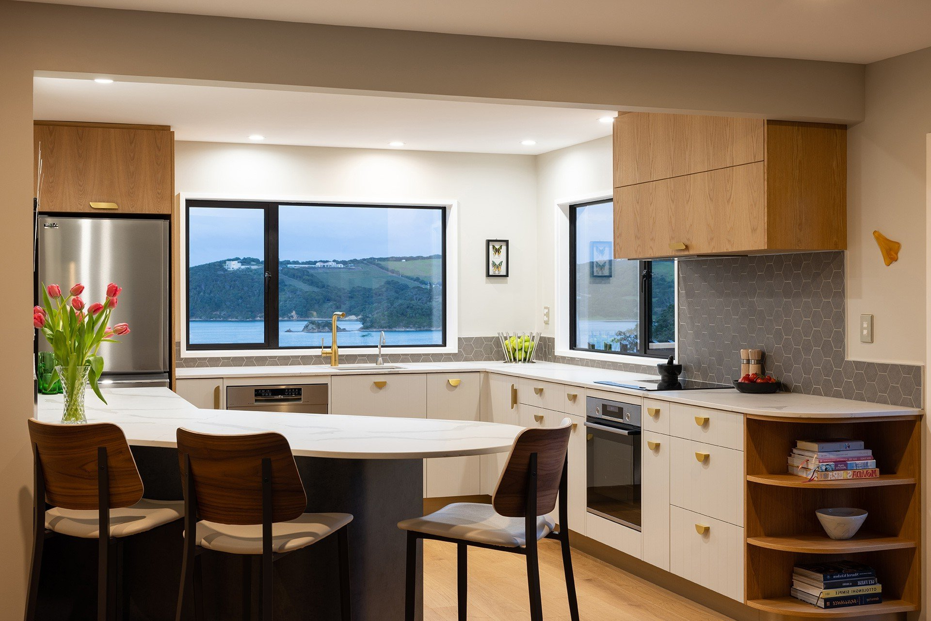 A kitchen with stainless steel appliances, wooden cabinets and a large island.