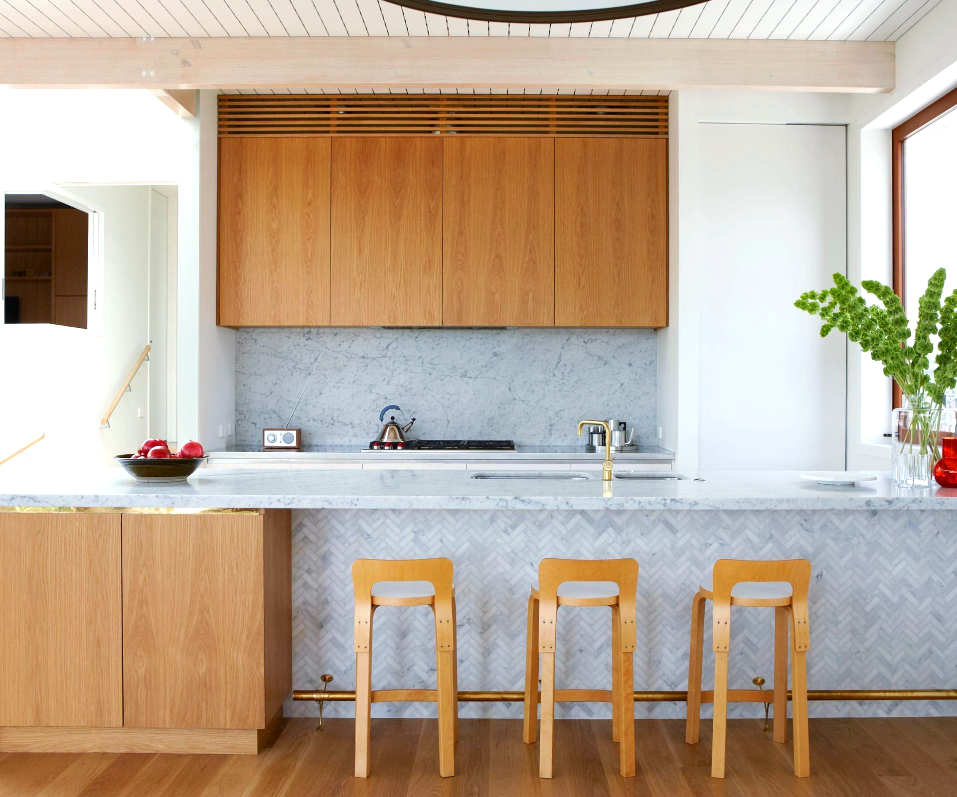 A kitchen with wooden cabinets and marble counter tops.