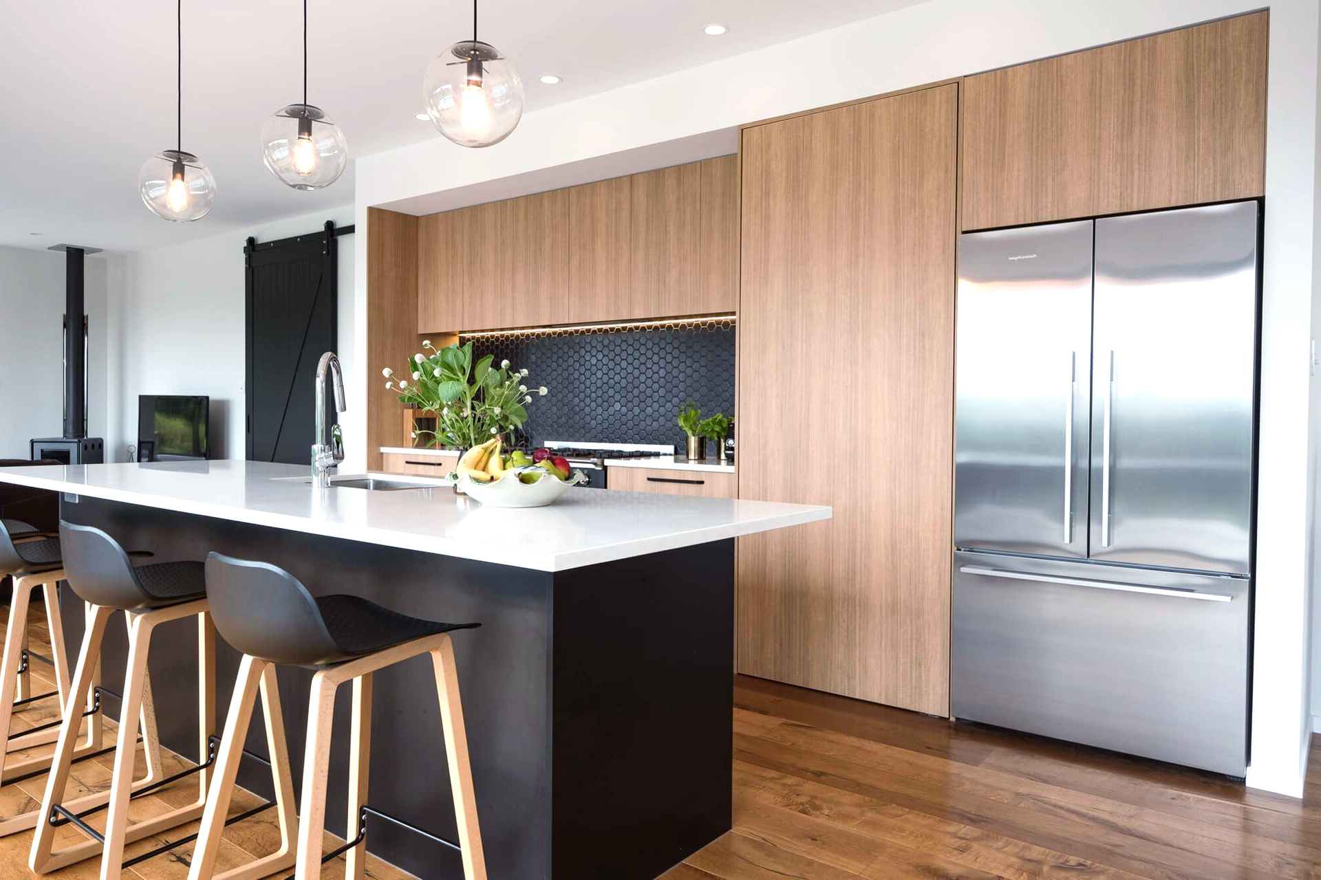 A kitchen with stainless steel appliances, wooden cabinets and a large island.