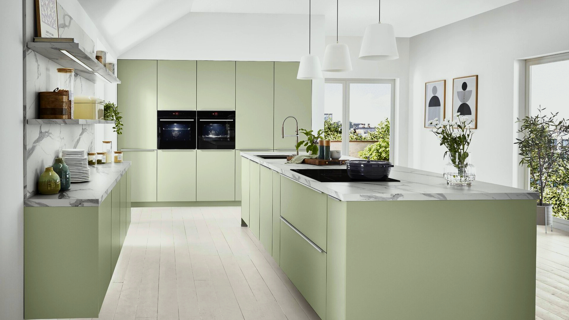 A kitchen with green cabinets and a large island in the middle.