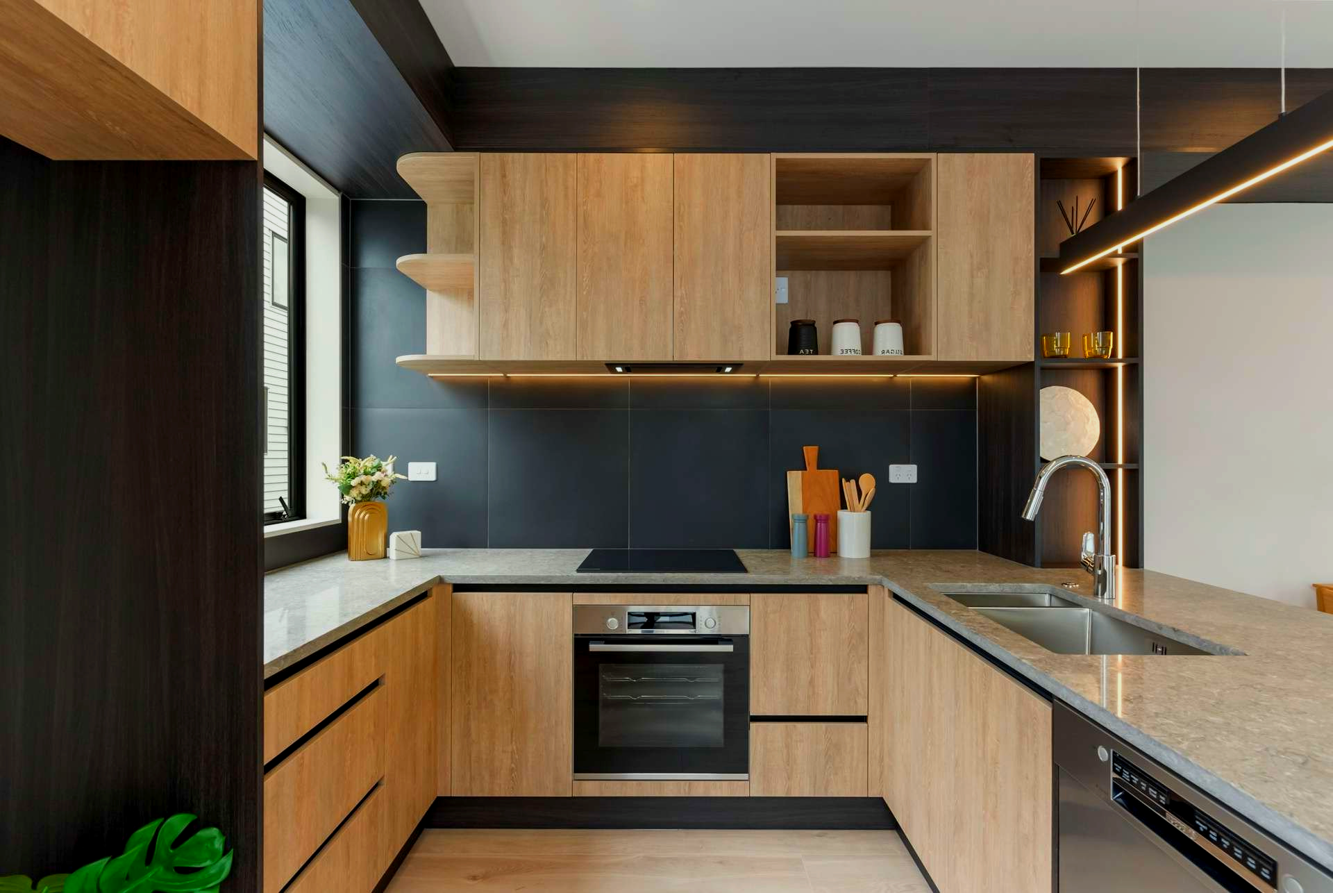 A kitchen with wooden cabinets, a stove, a sink, and a window.