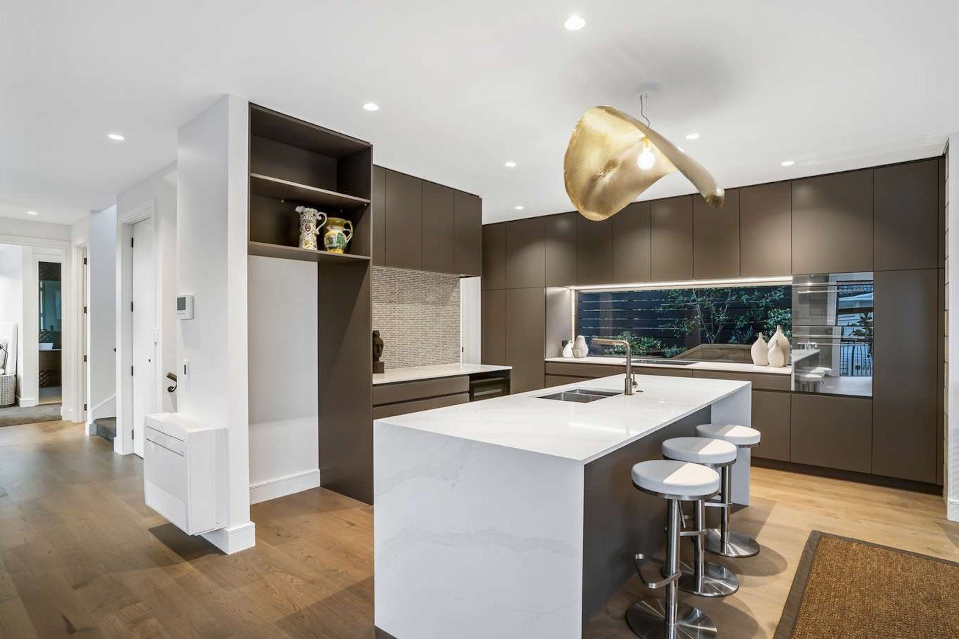 A modern kitchen with a large island and stools.