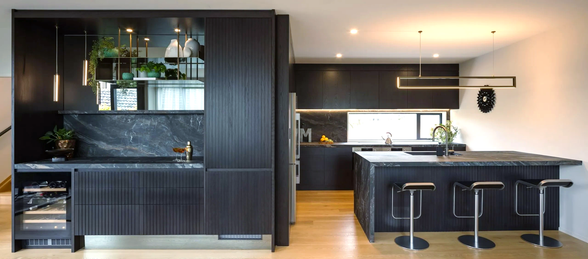 A kitchen with black cabinets and a large island.
