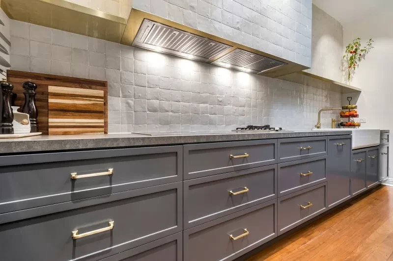 A kitchen with a lot of drawers and a stove top oven.