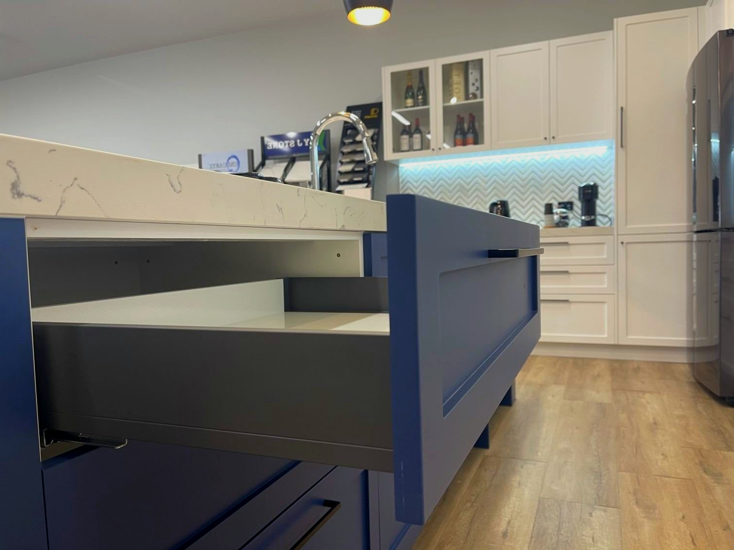 A kitchen with blue cabinets and a white counter top.