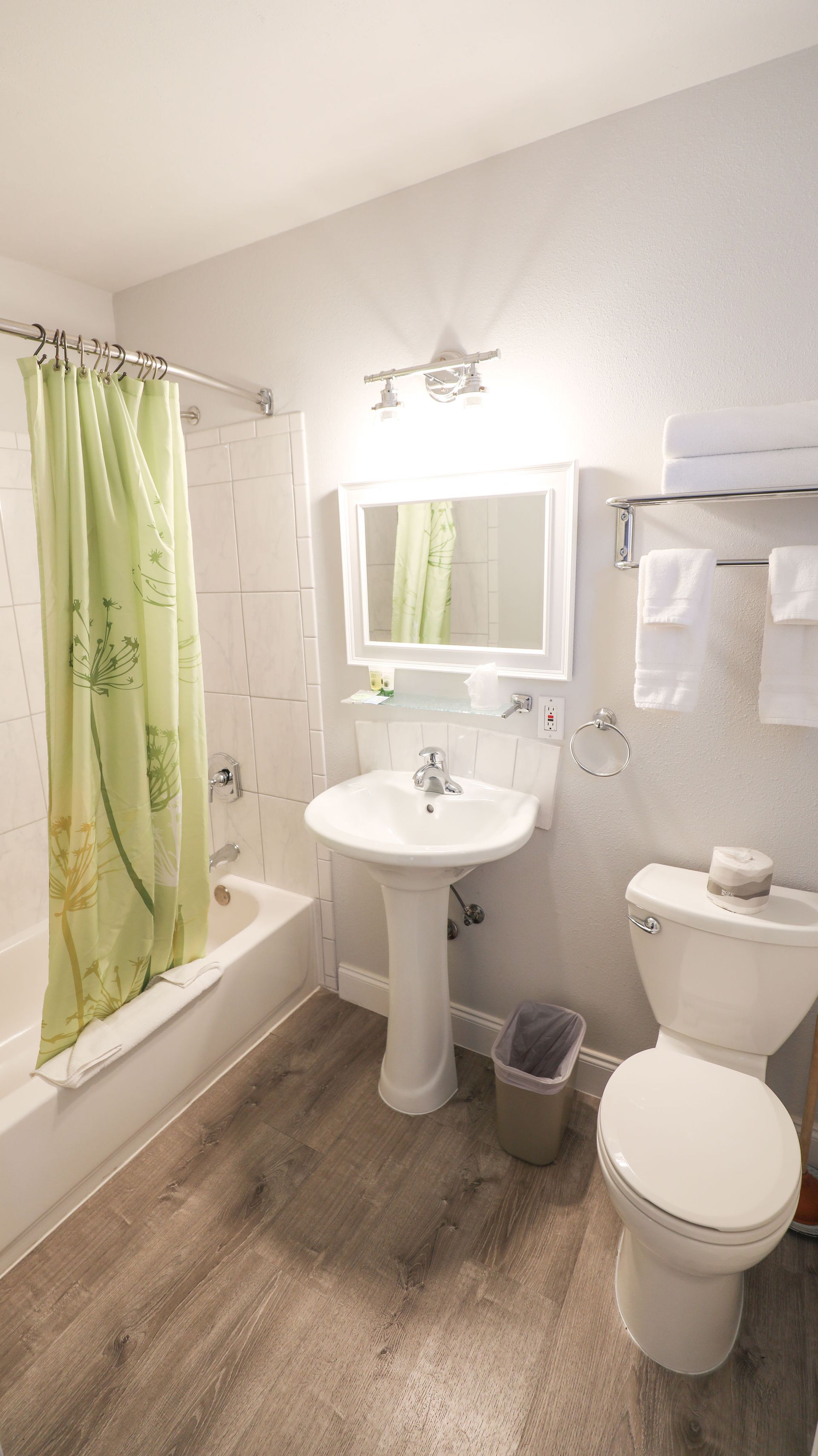 A bathroom with a sink , toilet , tub and mirror.