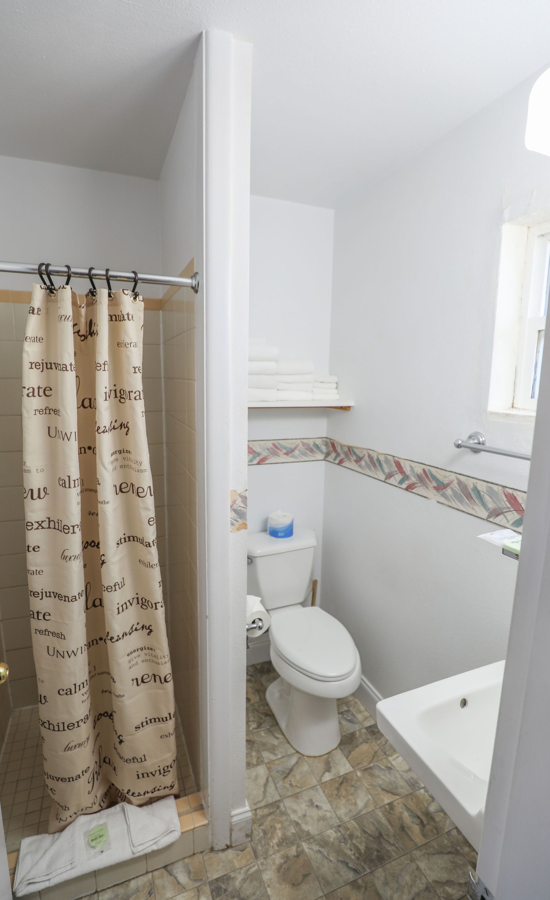 A bathroom with a toilet , sink and shower curtain.