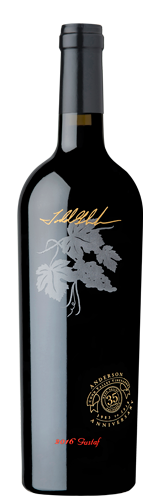 A dark bottle of wine featuring an embossed silver grapevine design and gold lettering on a black label.
