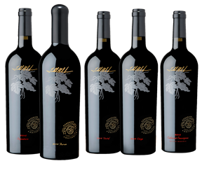 Five bottles of red wine standing in a row, featuring black glass with a silver leaf emblem and gold logo text.