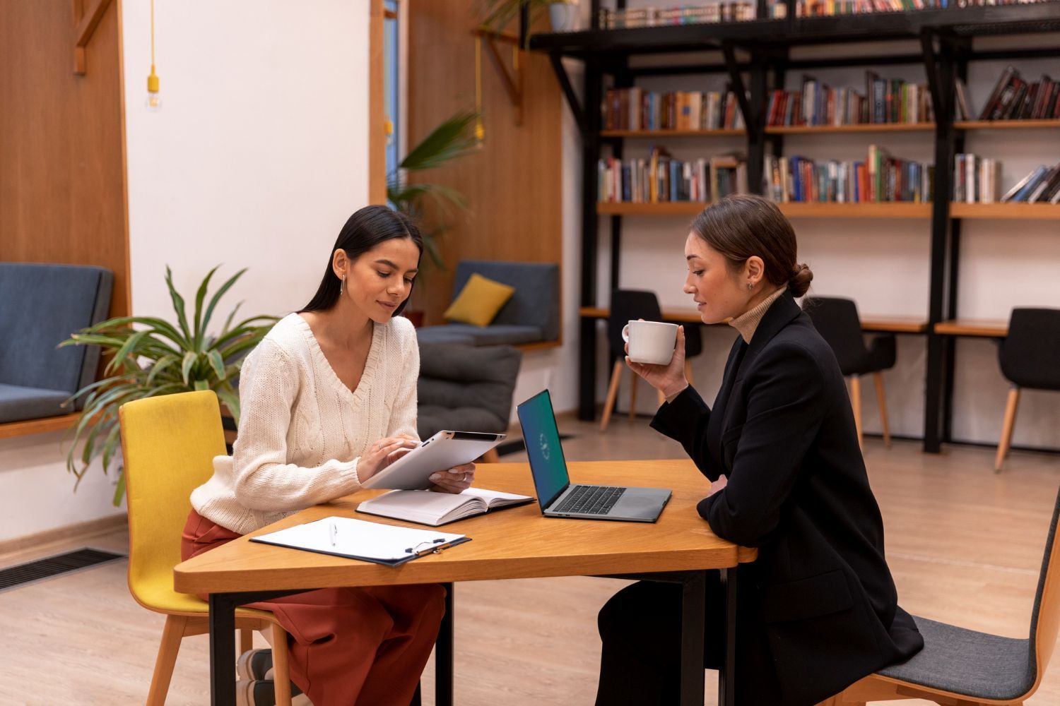 Colleagues in a meeting reviewing a document beside a laptop at a conference table