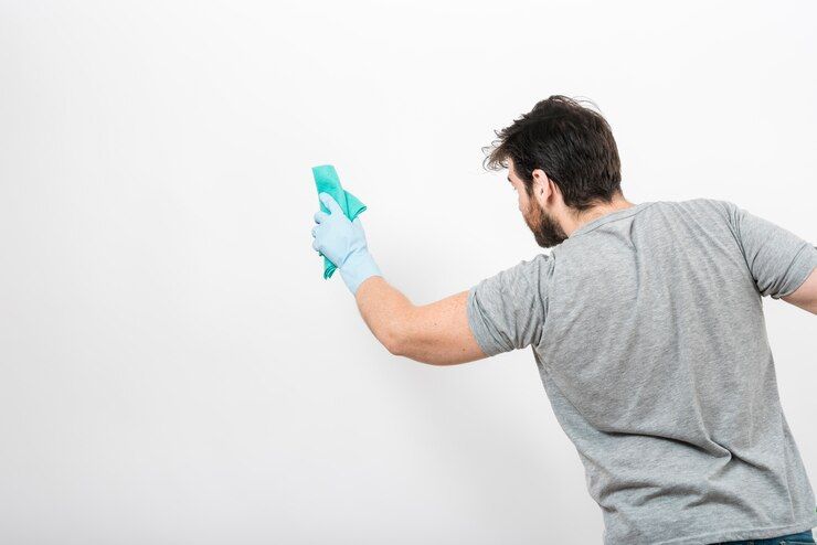 Man Cleaning White Wall - Cleaning Services in Darling Downs, QLD