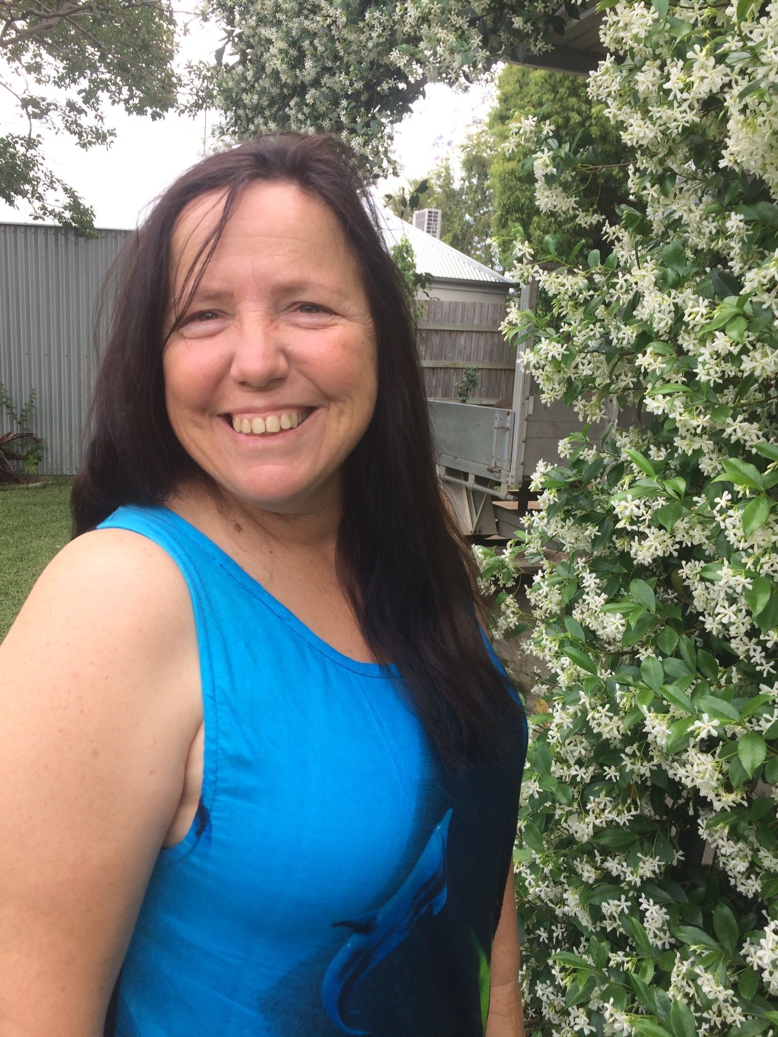 Woman standing infront of flowers- Cleaning Services in Darling Downs, QLD