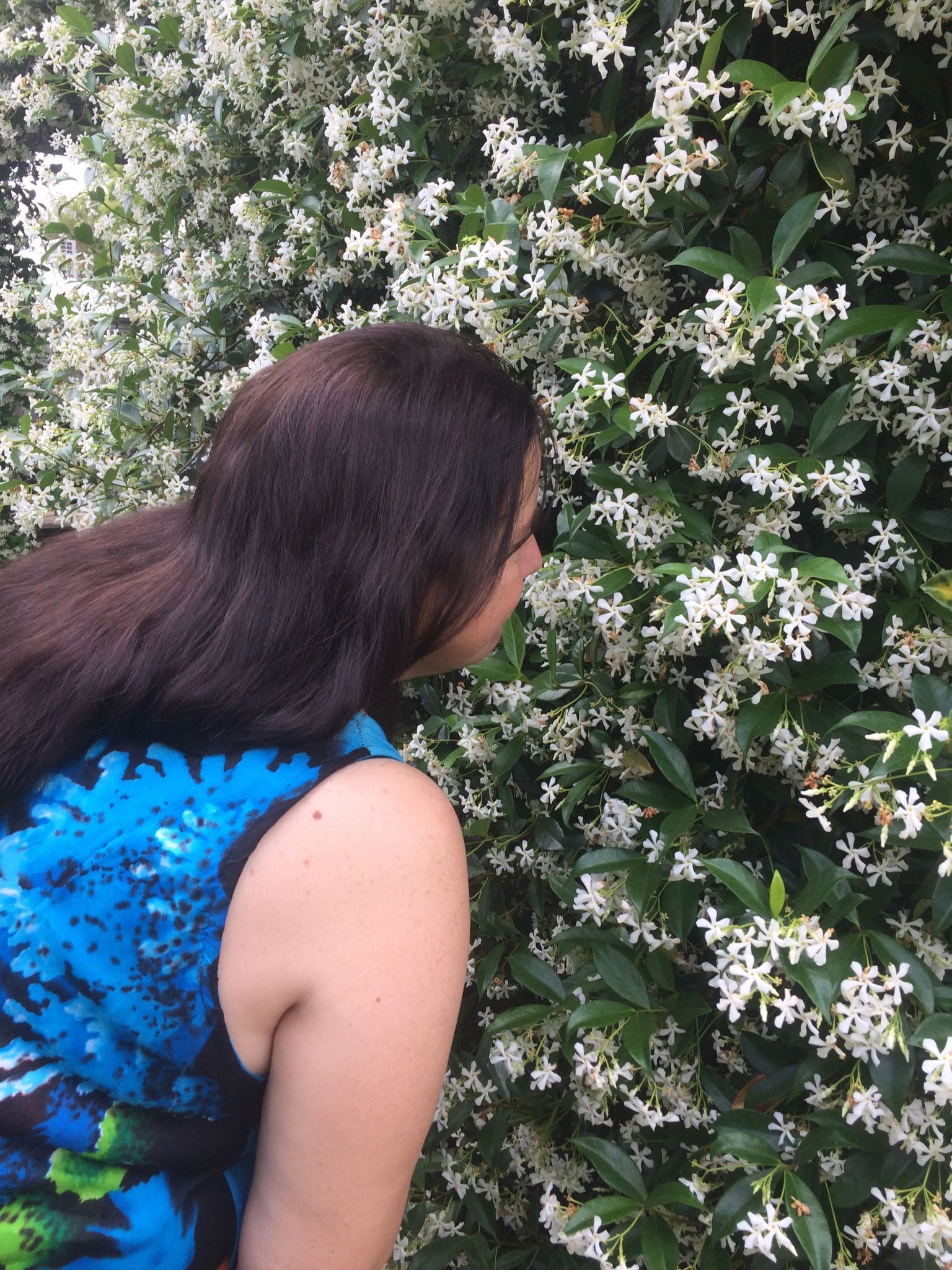 Woman smelling white flowers- Thorough Cleaner in Toowoomba, QLD