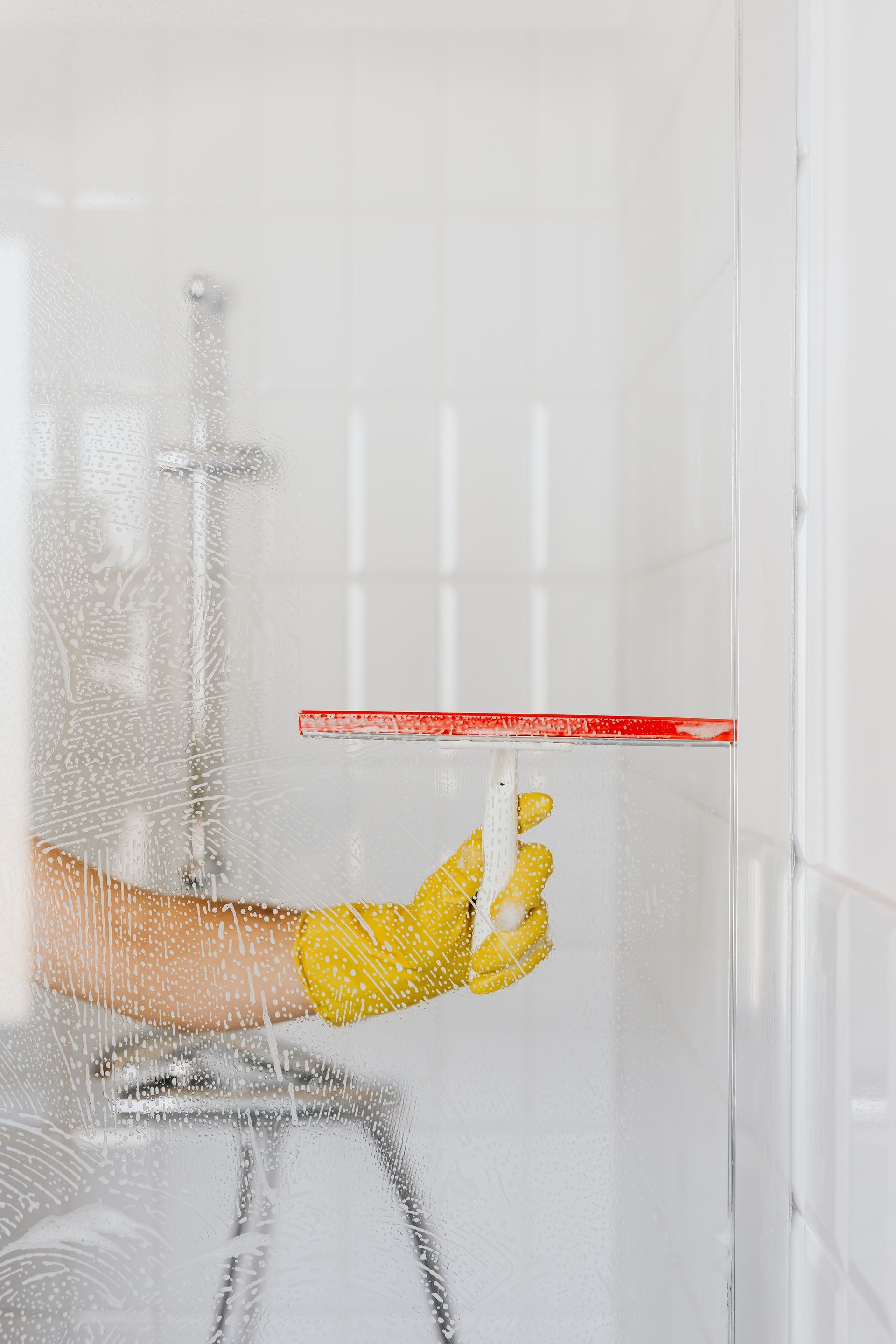 Wiping water off shower door - Experienced Cleaner in the Darling Downs, QLD