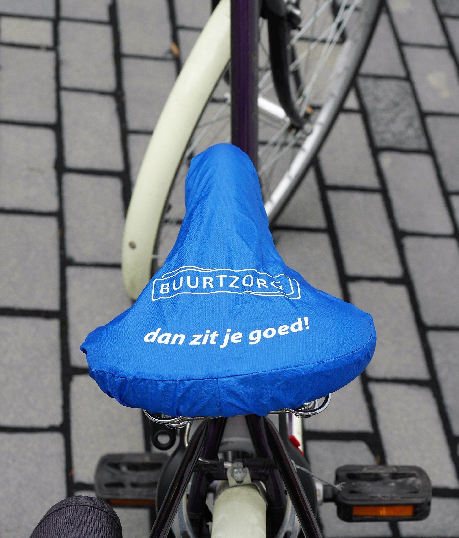 Bicycle seat with cover reading Buurtzorg - Dan zit je goed