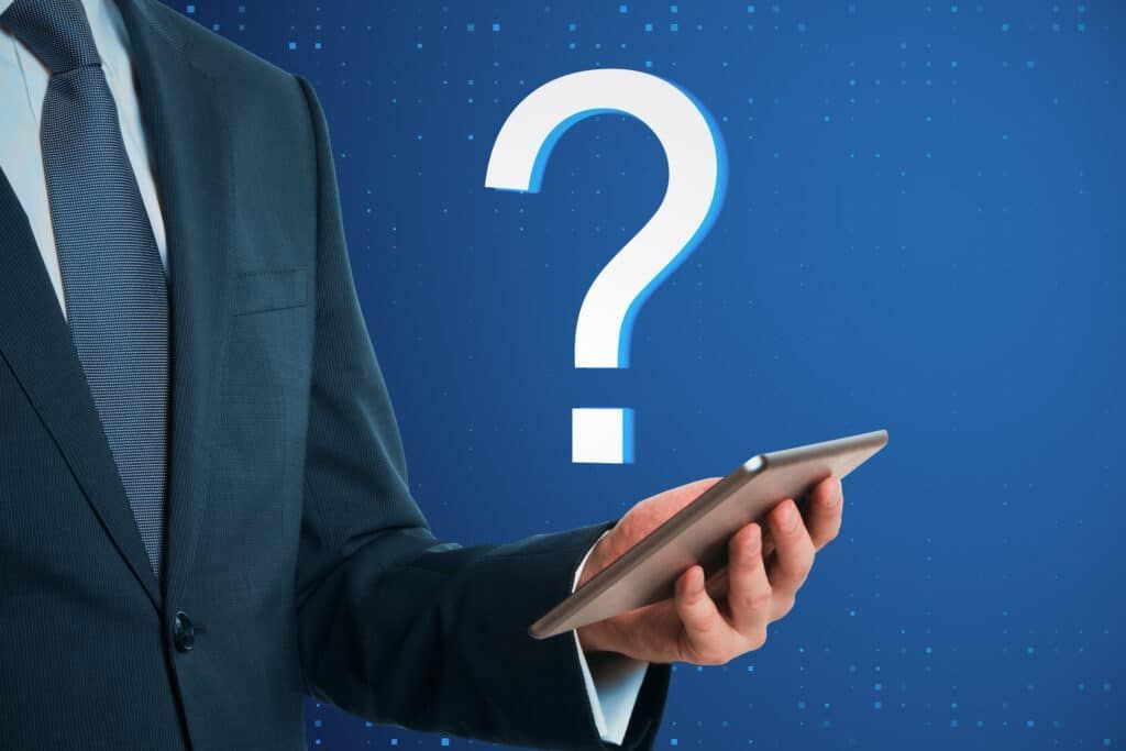 Man in suit holding tablet with a large question mark in background.