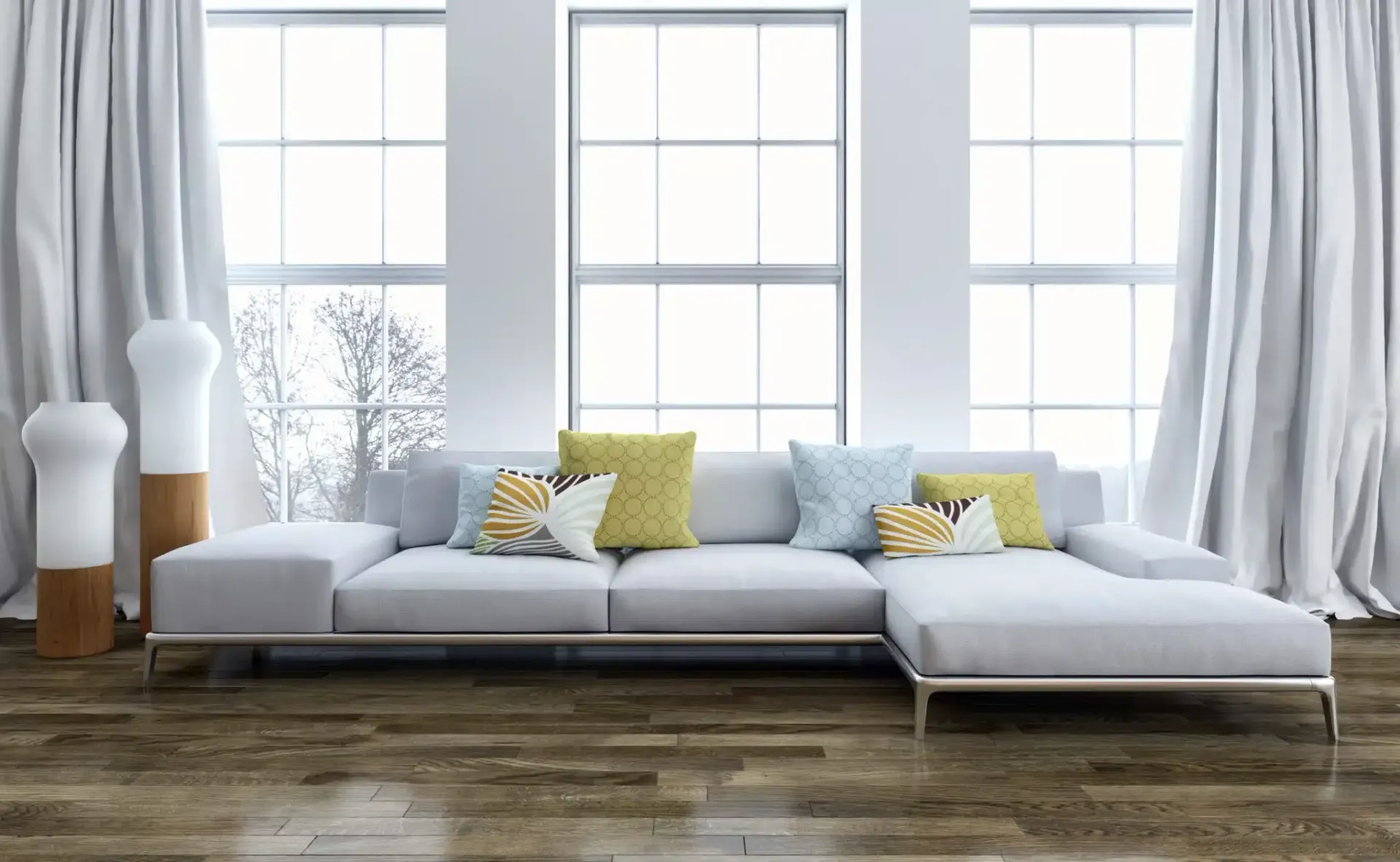 Modern living room with light gray sectional sofa, large windows, and hardwood floors.