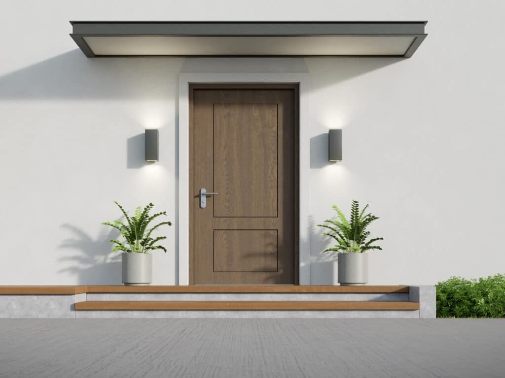 Front door of a modern house, with small steps, plants, and a canopy.