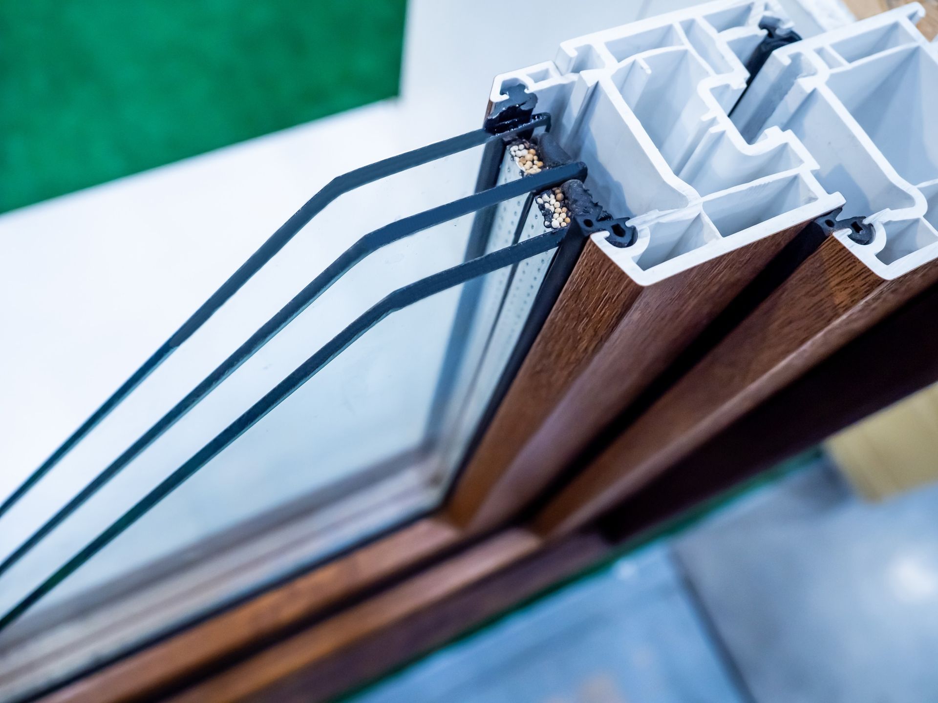 Cross-section of triple-pane window showing glass layers and white and brown frame.