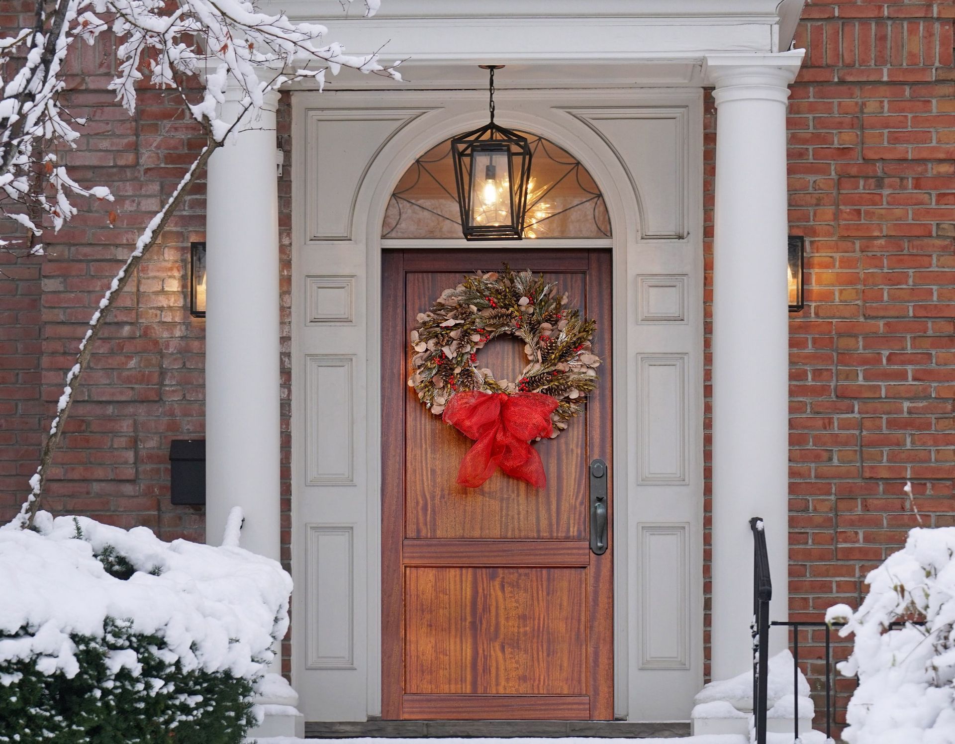 Elegant wood grain entry door with Christmas wreath.