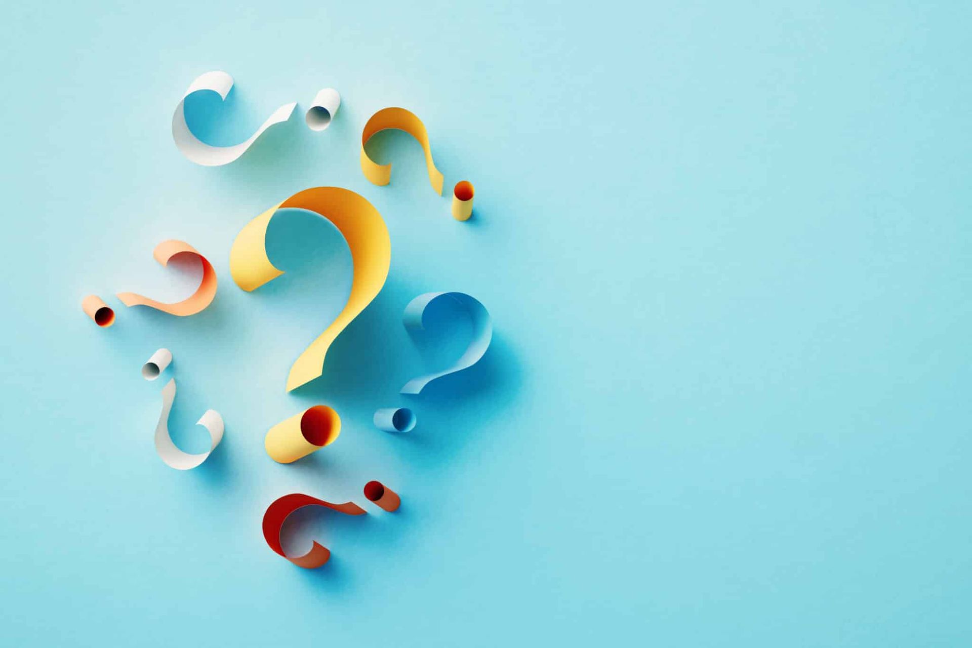 Colorful paper question marks scattered on a light blue background.