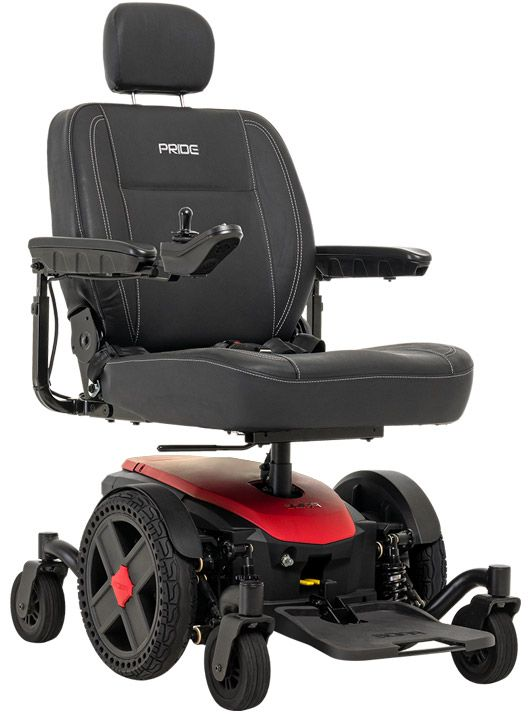 Close-up of a black joystick controller on a power wheelchair with a few buttons, set indoors with a blurred background.