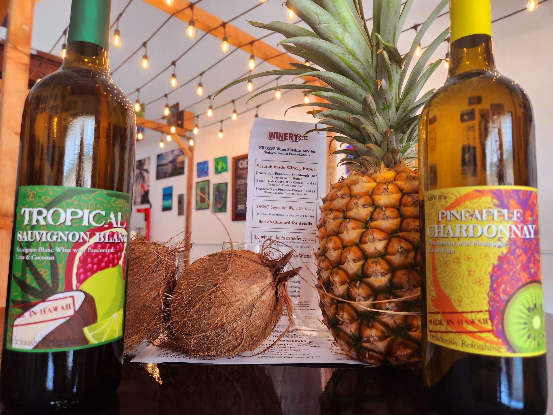 Two Bottles Of Tropical Wine Next To Pineapples And Coconuts | Kailua, HI | Oeno Winemaking