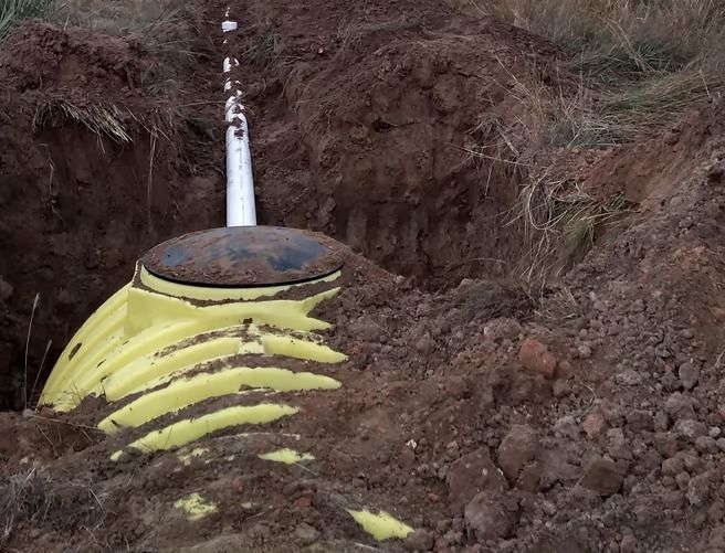 A yellow tank is sitting in the middle of a pile of dirt.